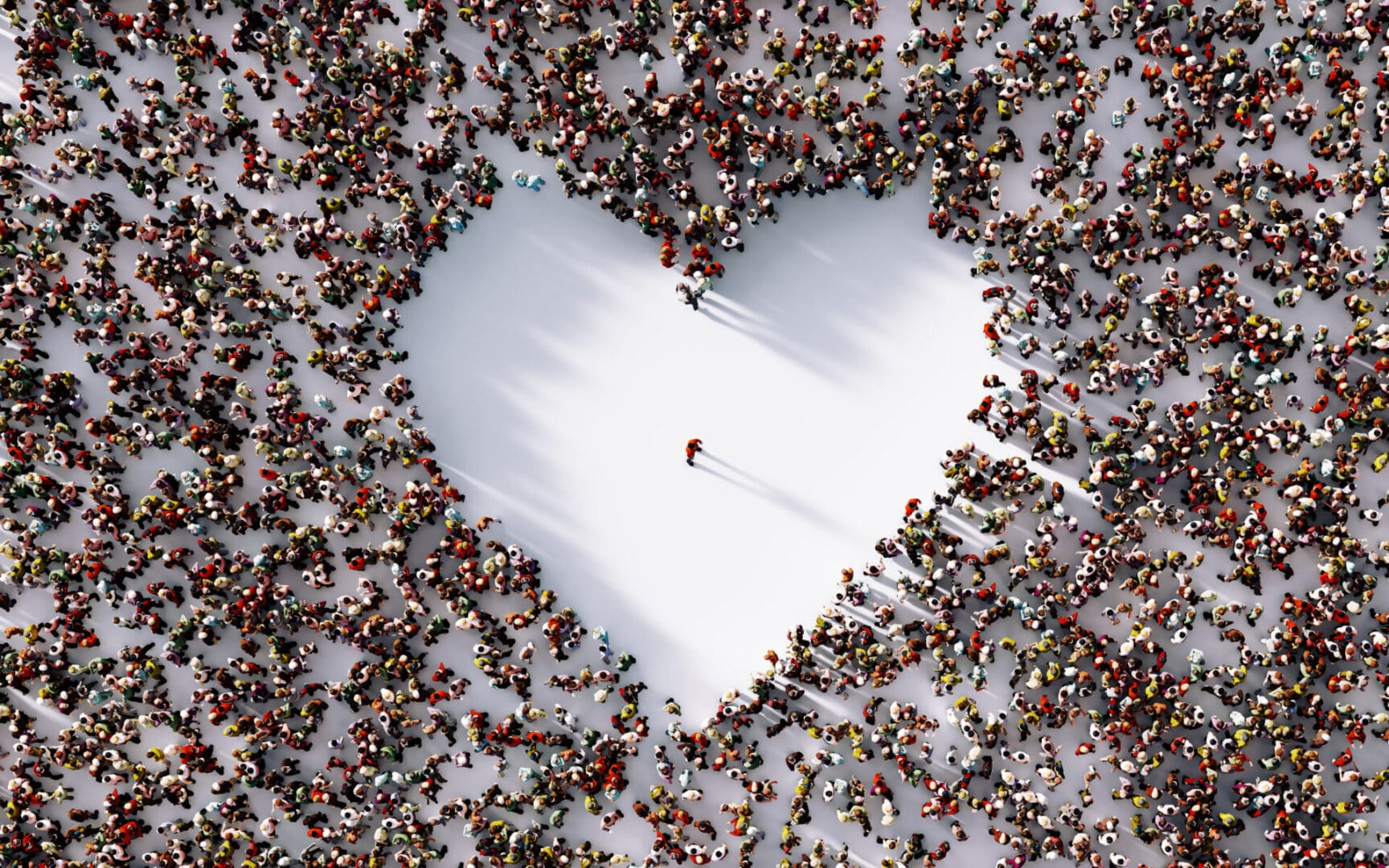 A heart shaped sign surrounded by people in the snow.