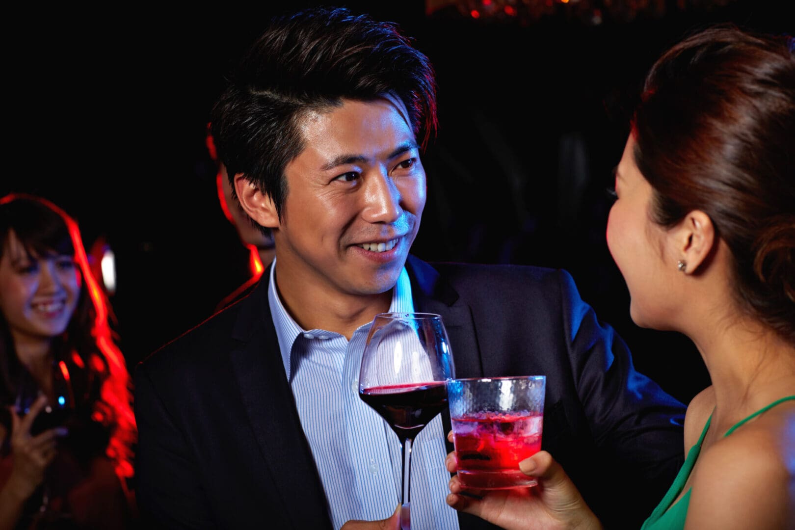 A man and woman holding wine glasses in front of him.