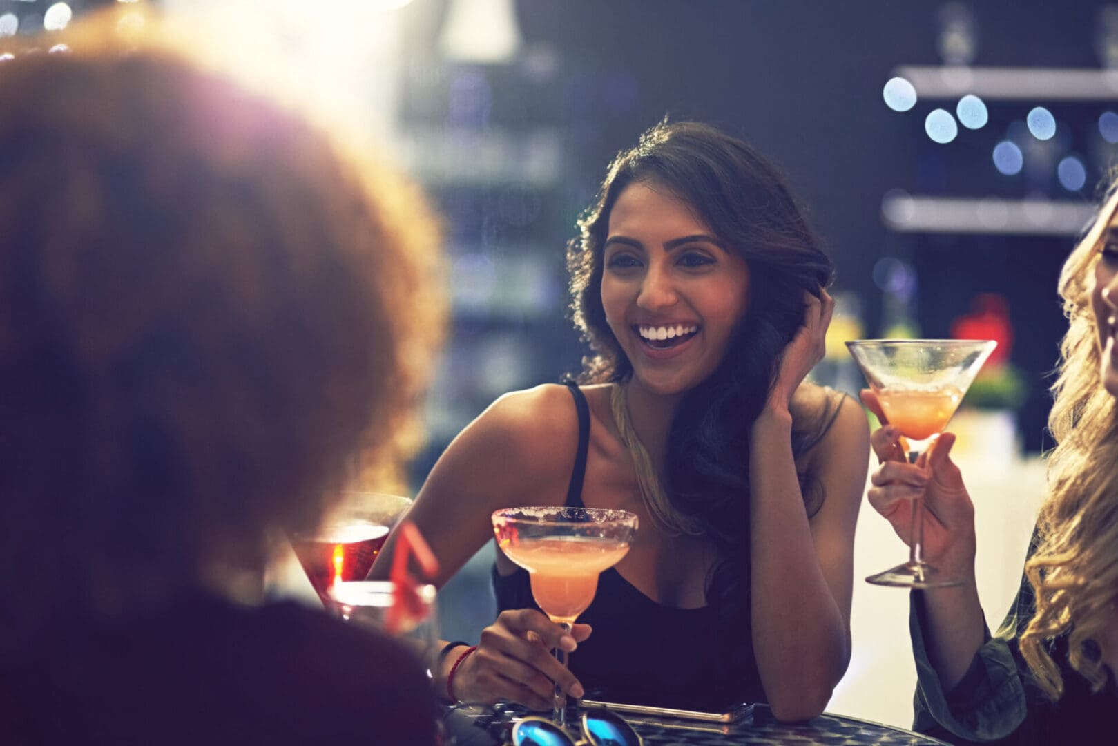 A woman sitting at a table with two other women.