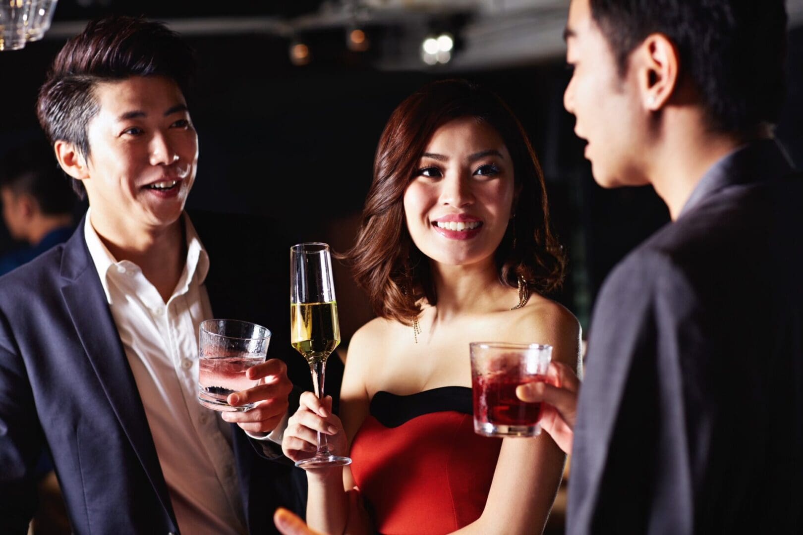 A group of people standing around each other holding drinks.